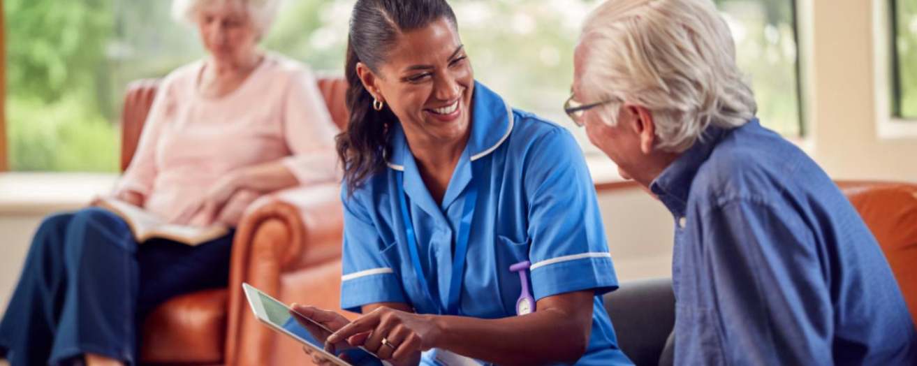 Care home worker who has completed safeguarding training assisting an elderly resident
